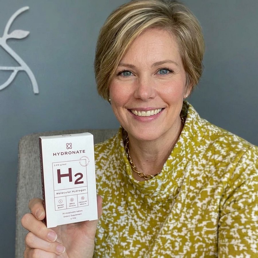 Customer holding a Hydronate H2 box, seated indoors.