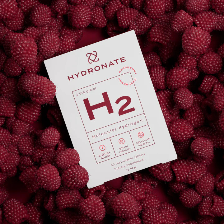 A Hydronate H₂ box resting on a dense bed of fresh raspberries